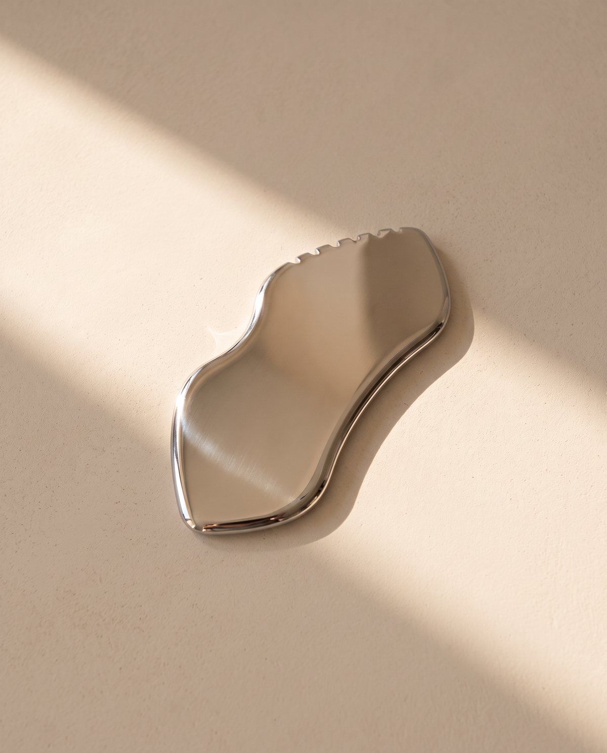 Gua sha vague en acier inoxydable SCULVORA, avec sa rangée de petites bosses