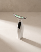 Lift Pro SCULVORA, appareil EMS visage et cou, coloris blanc nacré, posé sur un fond de plâtre écru