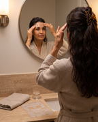 Femme posant la bande silicone sur son front devant le miroir, le soir