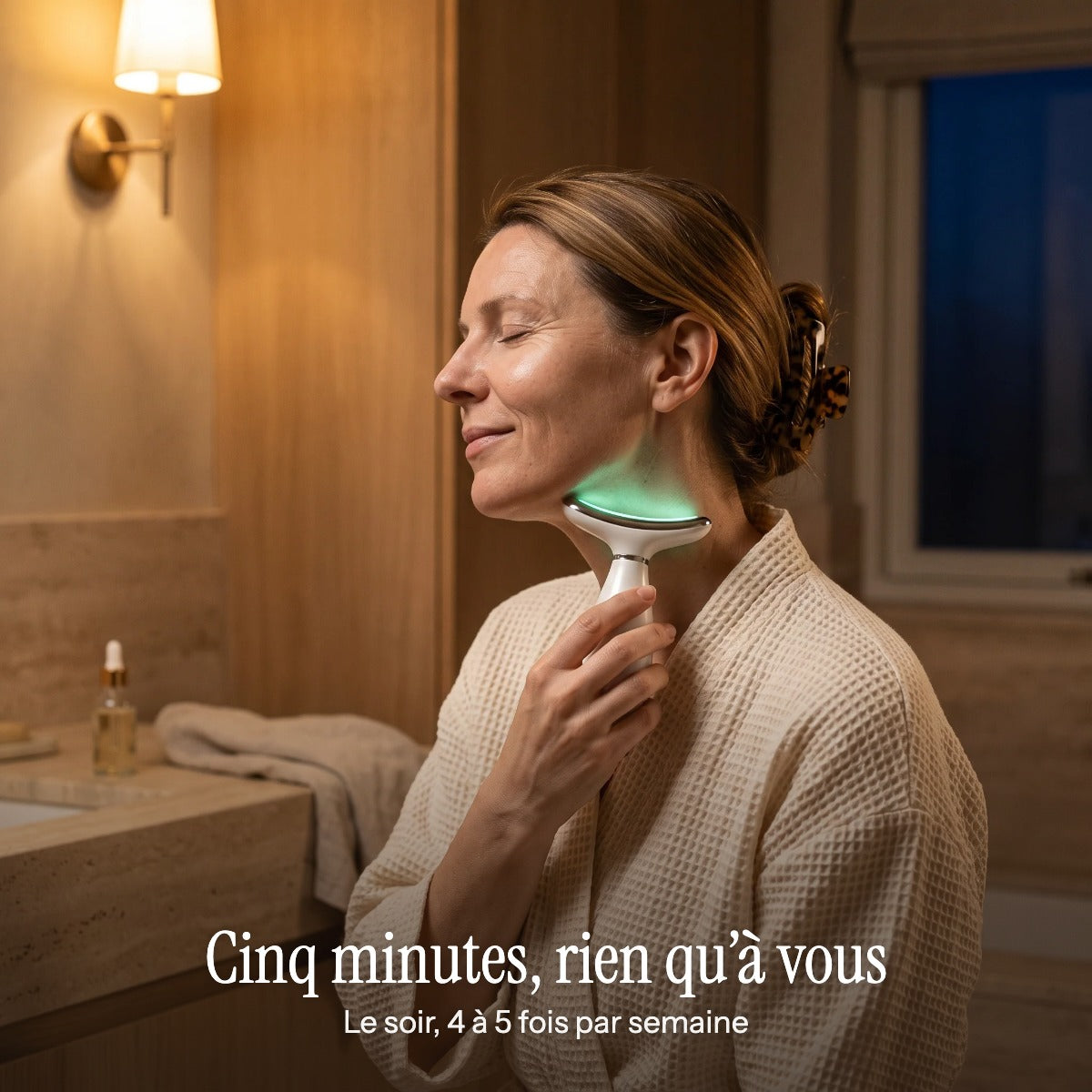 Le soir dans sa salle de bain, une femme passe le Lift Pro sur son cou : cinq minutes rien qu'à vous, 4 à 5 fois par semaine