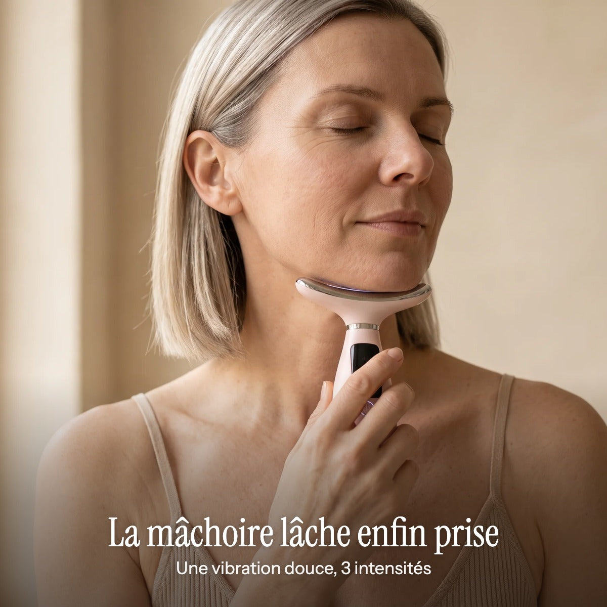 Une femme les yeux fermés, le Lift Pro sous la mâchoire : une vibration douce en 3 intensités
